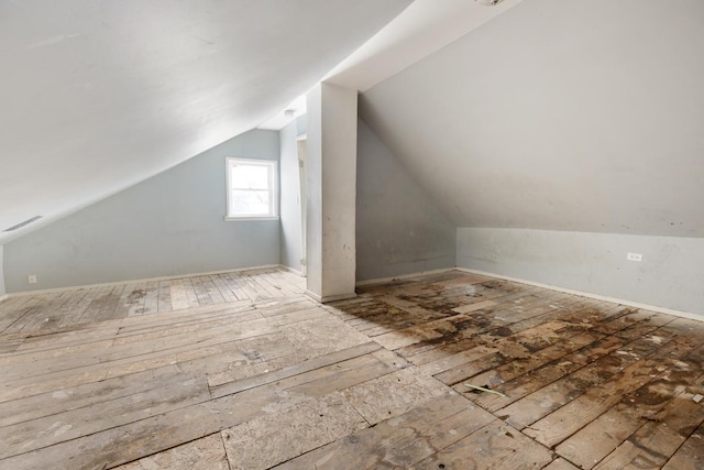 additional living space with hardwood / wood-style flooring and vaulted ceiling