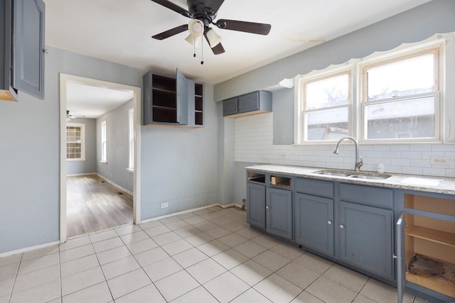 kitchen with ceiling fan, plenty of natural light, sink, and light tile patterned floors