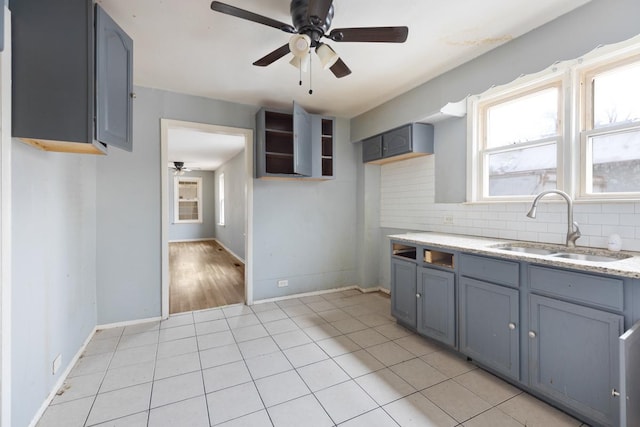 kitchen with ceiling fan, sink, gray cabinets, decorative backsplash, and light tile patterned floors