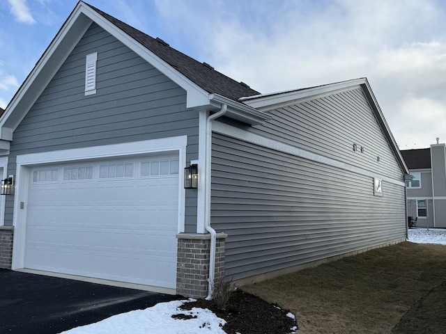 view of snow covered exterior featuring a garage