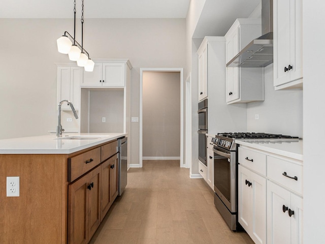 kitchen with sink, white cabinets, wall chimney exhaust hood, and appliances with stainless steel finishes