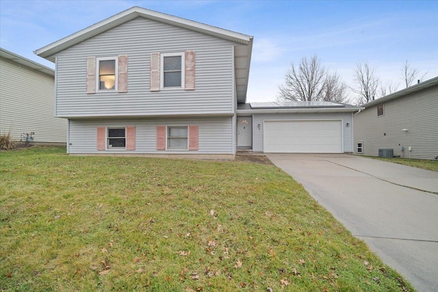 view of front of home featuring central AC, a front yard, and a garage