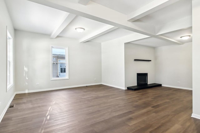 unfurnished living room featuring dark hardwood / wood-style flooring and beam ceiling