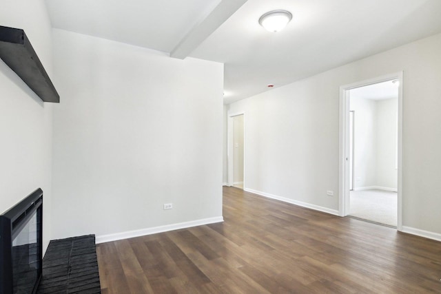 unfurnished living room featuring beam ceiling, a brick fireplace, and dark hardwood / wood-style floors