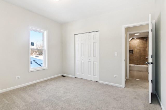 unfurnished bedroom with light colored carpet and a closet