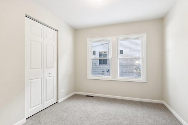 unfurnished bedroom with a closet and carpet flooring