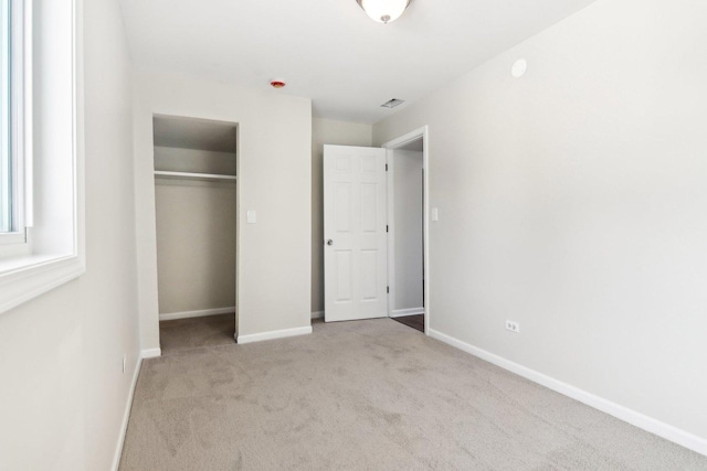 unfurnished bedroom featuring a closet and light carpet