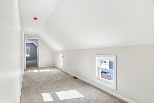 bonus room featuring vaulted ceiling and light carpet