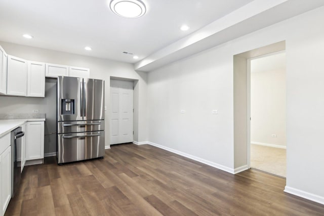 kitchen with white cabinets, stainless steel fridge, black dishwasher, and dark hardwood / wood-style flooring