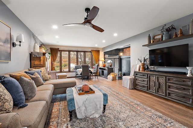 living room featuring ceiling fan and light wood-type flooring