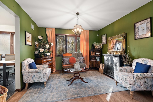 sitting room with an inviting chandelier and hardwood / wood-style flooring