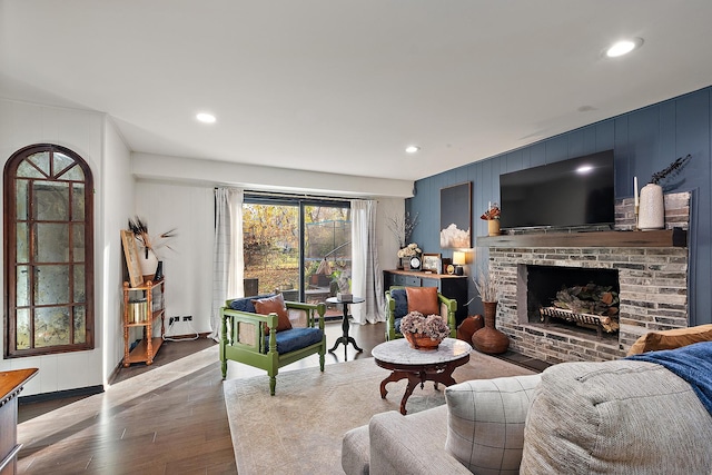 living room with a fireplace and wood-type flooring