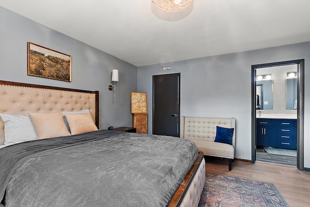 bedroom with light hardwood / wood-style floors and ensuite bath