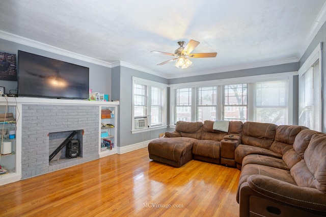 living room with light wood-type flooring, a brick fireplace, ceiling fan, and crown molding