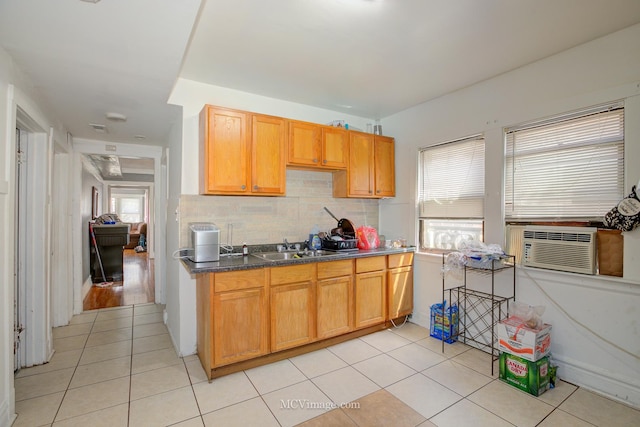 kitchen with light tile patterned flooring, backsplash, cooling unit, and sink