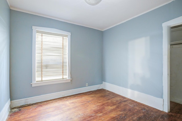 empty room featuring hardwood / wood-style floors and ornamental molding