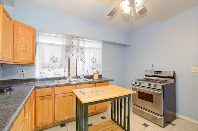 kitchen featuring sink, gas stove, ceiling fan, and light tile patterned flooring