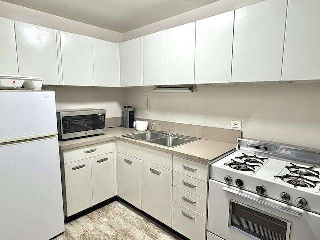 kitchen featuring white cabinetry, sink, range with gas cooktop, and white refrigerator