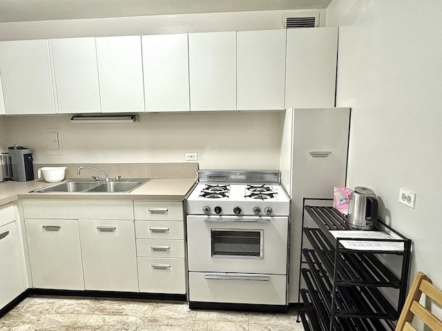 kitchen with white range oven, sink, and white cabinets