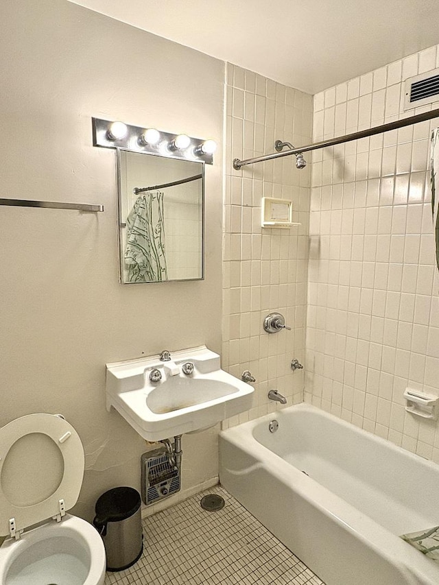 full bathroom featuring tile patterned floors, toilet, shower / bath combo with shower curtain, and sink