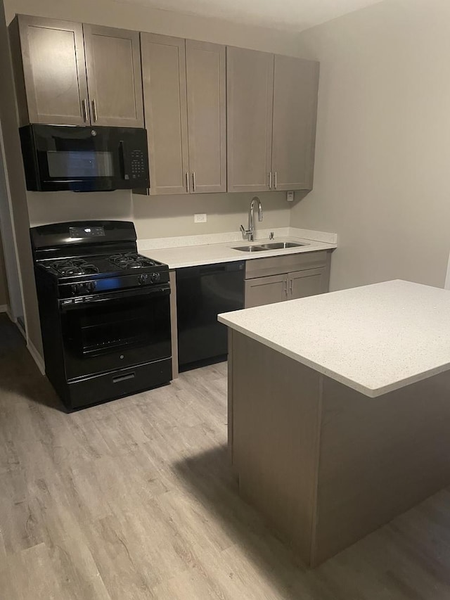 kitchen featuring gray cabinetry, sink, black appliances, and light hardwood / wood-style floors