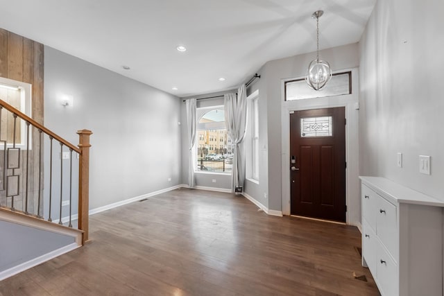 entrance foyer with dark hardwood / wood-style floors and an inviting chandelier