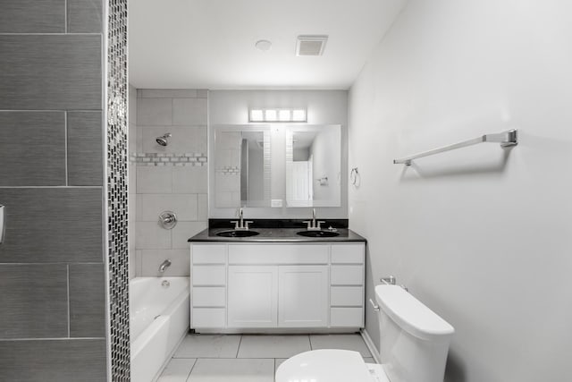 full bathroom featuring tile patterned floors, vanity, tiled shower / bath combo, and toilet