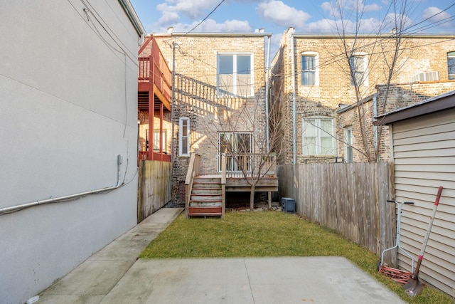 back of house featuring a wooden deck, a yard, and central AC