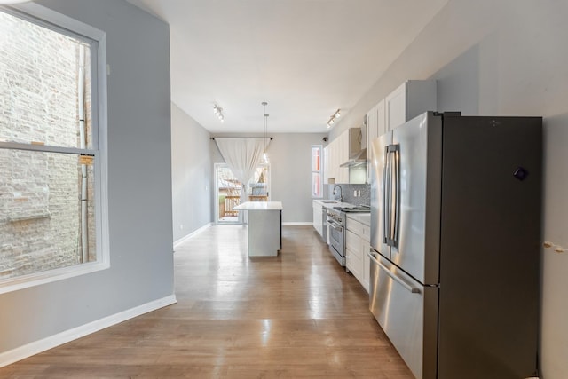 kitchen with white cabinetry, sink, a center island, pendant lighting, and appliances with stainless steel finishes