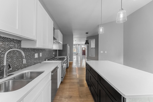 kitchen with white cabinetry, sink, hanging light fixtures, and stainless steel appliances