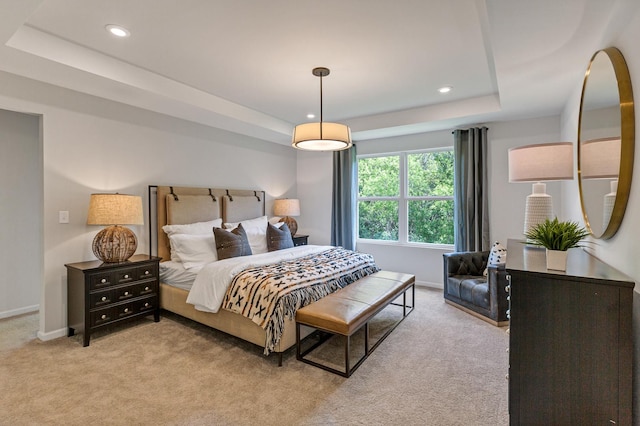 bedroom featuring a raised ceiling and light colored carpet