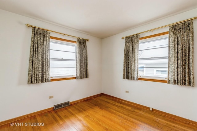 unfurnished room featuring hardwood / wood-style flooring and a healthy amount of sunlight