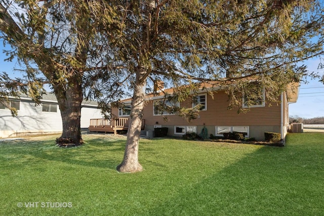 rear view of property featuring a yard, central air condition unit, and a wooden deck