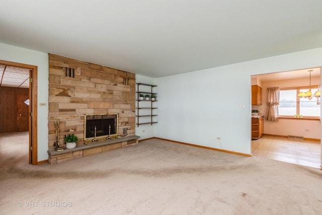 unfurnished living room with a fireplace, carpet floors, and an inviting chandelier