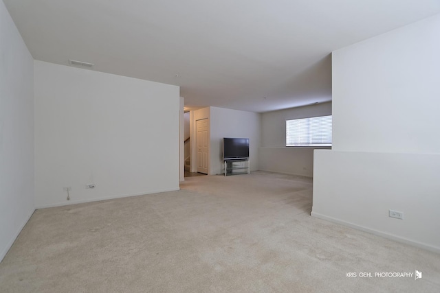 unfurnished living room featuring light carpet