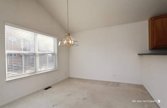 unfurnished dining area with light carpet, lofted ceiling, and a notable chandelier