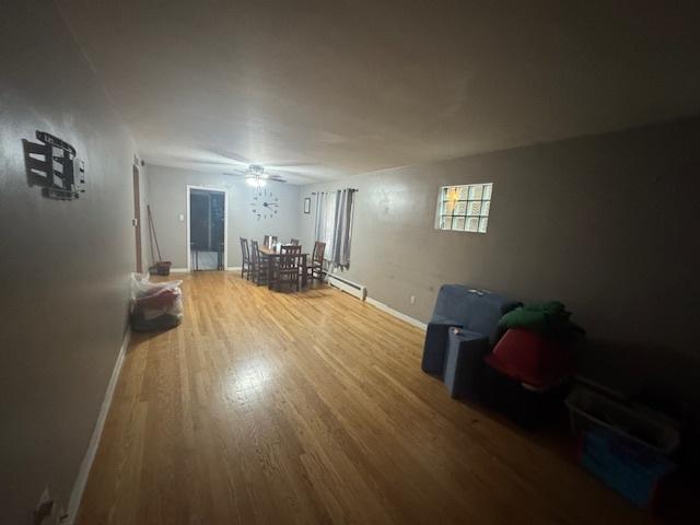 living room featuring ceiling fan, hardwood / wood-style floors, and a baseboard radiator