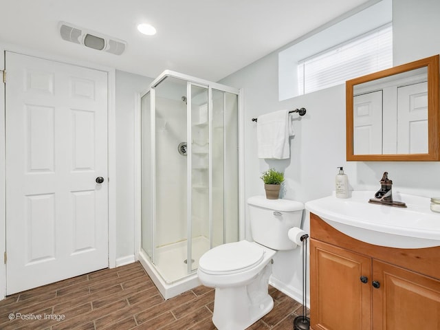 bathroom with an enclosed shower, vanity, and toilet