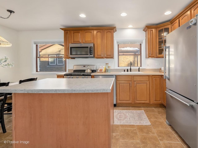 kitchen featuring a healthy amount of sunlight, pendant lighting, stainless steel appliances, a breakfast bar, and sink