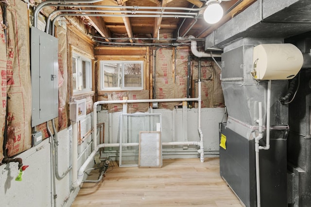 utility room featuring electric panel and heating unit