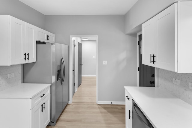 kitchen with decorative backsplash, white cabinetry, stainless steel appliances, and light wood-type flooring