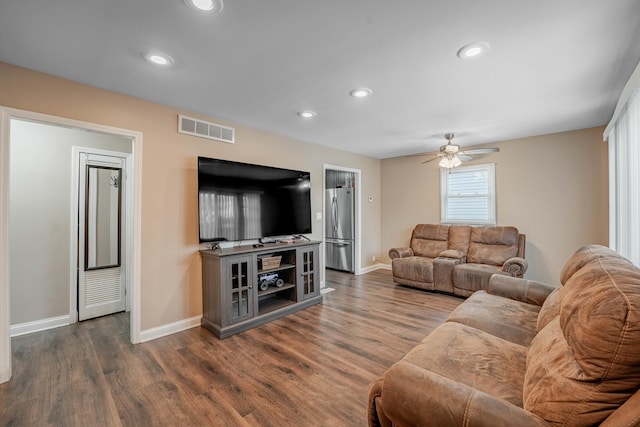 living room with ceiling fan and dark hardwood / wood-style flooring