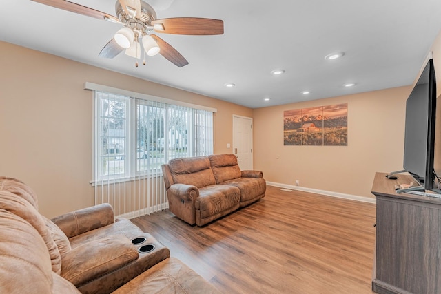 living room with light hardwood / wood-style floors and ceiling fan