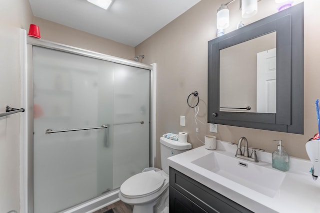 bathroom featuring vanity, an enclosed shower, and toilet