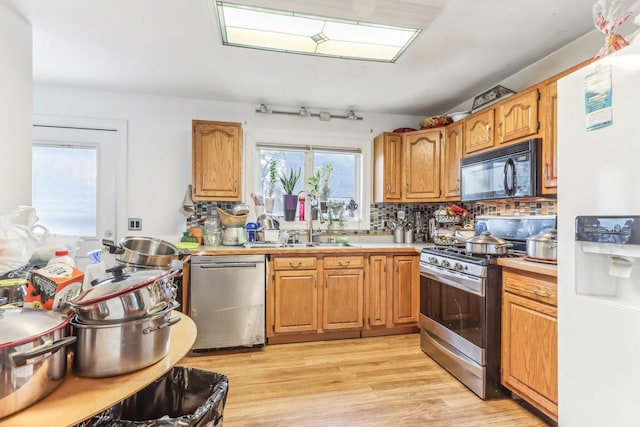 kitchen featuring light hardwood / wood-style flooring, sink, appliances with stainless steel finishes, and tasteful backsplash