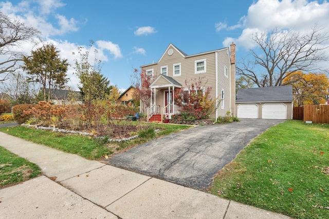 view of front of home featuring a front yard, an outdoor structure, and a garage