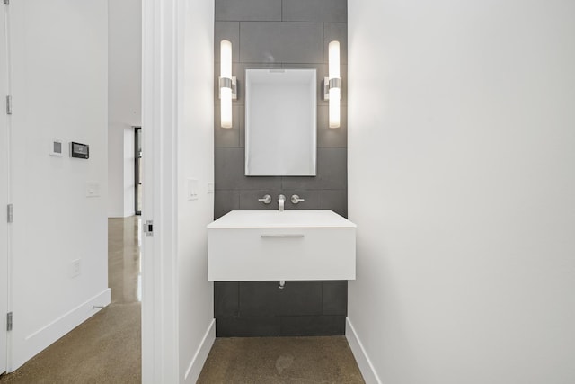 bathroom featuring tile walls and sink