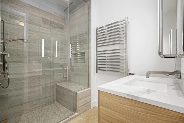 bathroom with radiator, a shower with door, and vanity