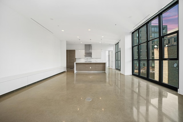 unfurnished room featuring floor to ceiling windows and sink