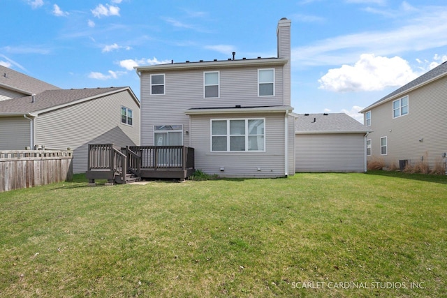 back of property with a lawn and a deck